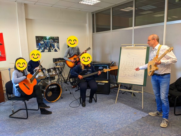 Professeur de guitare donnant un cours à domicile à un élève jouant de la guitare classique à Rueil-Malmaison